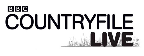 BBC Country file Live logo, displayed in black on a white background. Made from mostly strong black text with a pretty and light illustration in the bottom left hand corner of flowers and grass