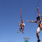 Fun corporate event showing man and young man zip lining down a wire